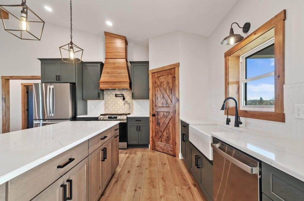 Modern kitchen featuring custom wood range hood, sleek cabinetry, stainless steel appliances, and quartz countertops, emphasizing aesthetic appeal and functionality.